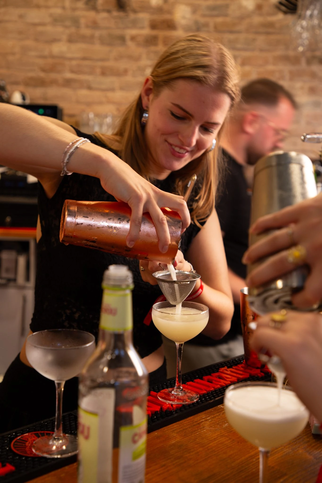 cocktail-wordt-door-een-deelnemer-gezeefd-in-een-coupeglas-tijdens-de-workshop - kopie